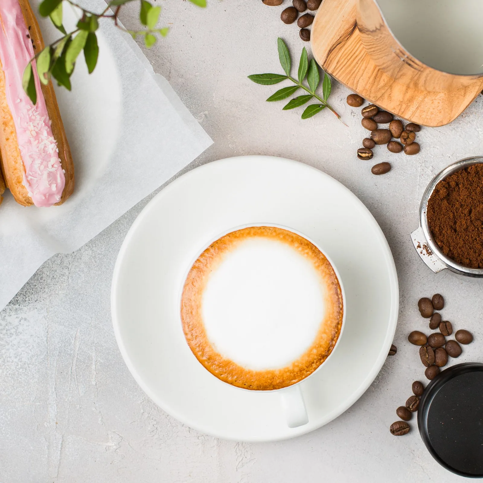 Cappuccino and éclair on a marble table